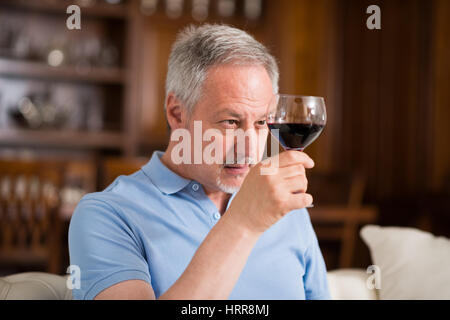 Portrait d'un homme mûr bénéficiant d''un verre de vin rouge à la maison Banque D'Images