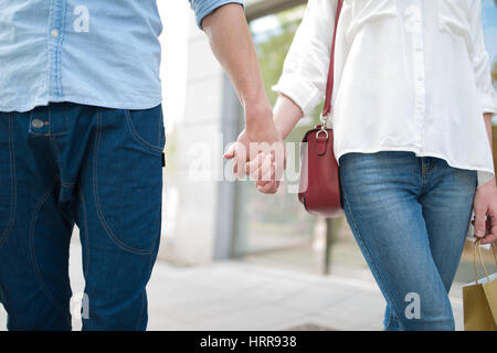 Couple en train de marcher dans une ville main dans la main Banque D'Images