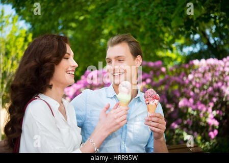 Portrait d'un couple heureux de manger une glace dans un parc Banque D'Images