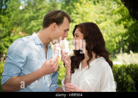 Portrait d'un couple heureux de manger une glace dans un parc Banque D'Images