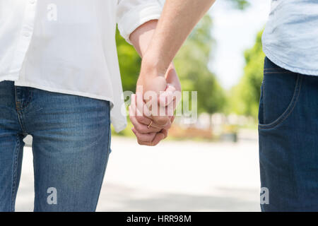 Couple en train de marcher dans une ville main dans la main Banque D'Images