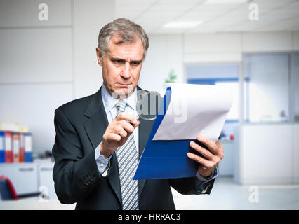 L'analyse d'affaires d'un document dans son bureau Banque D'Images