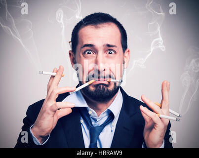 Businessman smoking nerveux beaucoup de cigarettes à la fois Banque D'Images