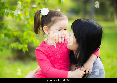 Libre d'adulte de happy mother and daughter in spring park. Peu drôle de fille 4 ans age jouer dehors avec ses parents à spring city park Banque D'Images