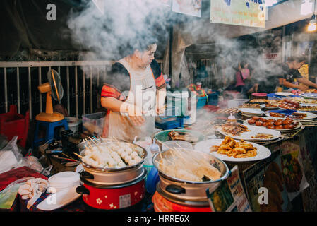 Chiang Mai, Thaïlande - 27 août 2016 : femme thaïlandaise cuit les aliments en vente au marché du samedi soir le 27 août 2016 à Chiang Mai, Thaïlande. Banque D'Images