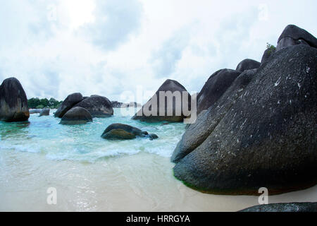 Natural black rock formation sur le bord de la mer à la plage dans l'île de Belitung dans la journée, l'Indonésie. Banque D'Images