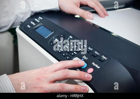 L'homme à l'aide de dispositifs multifonctions scanner in office Banque D'Images