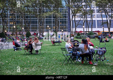 NEW YORK - 26 septembre 2016 : des gens assis dans Bryant Park à petit café tables et chaises, de boire et manger Banque D'Images