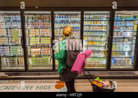 Un client choisit un café gratuitement oeufs dans une glacière dans le nouveau Whole Foods Market à Newark, NJ le jour d'ouverture le Mercredi, Mars 1, 2017. Le magasin est le 17e de la chaîne de magasin ouvert dans le New Jersey. Le magasin de 29 000 pieds carrés situé dans l'ancienne réaménagée Hahne & Co. department store bâtiment est considéré comme un présage de la revitalisation de la Newark qui jamais remis des émeutes dans les années 1960. (© Richard B. Levine) Banque D'Images