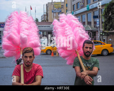 La BARBE À PAPA ROSE SACS ET TENUE SUR PERCHE LIVRÉ PAR DEUX HOMMES TURCS ISTANBUL Turquie Banque D'Images