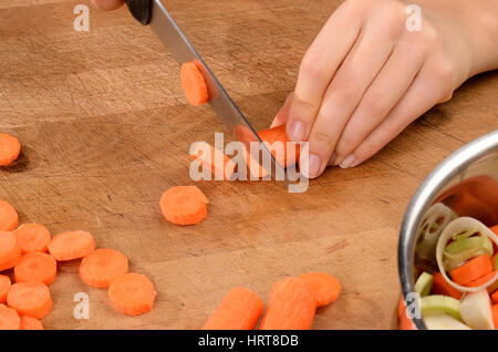 Jeune femme des carottes sur une planche à découper. Banque D'Images