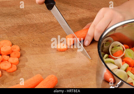 Jeune femme des carottes sur une planche à découper. Banque D'Images
