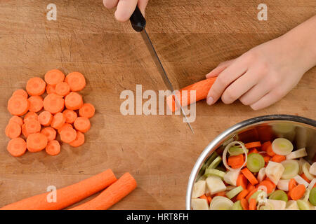 Jeune femme des carottes sur une planche à découper. Banque D'Images