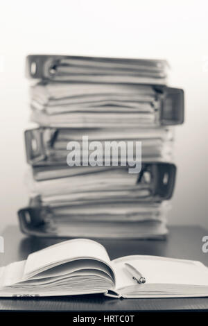 Sept cinq dossiers avec documents empilés dans une pile sur la table. Photo en noir et blanc Banque D'Images