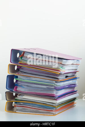 Cinq dossiers avec documents empilés dans une pile sur la table. Fond blanc Banque D'Images