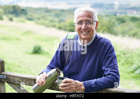 Senior Man On Randonnée pédestre ayant boisson chaude Banque D'Images