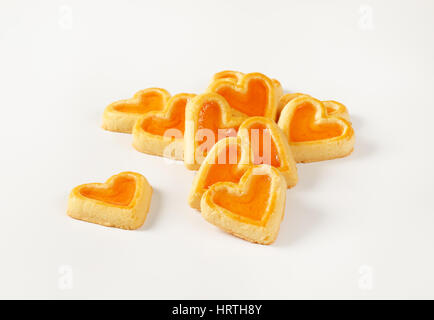 Les cookies en forme de cœur avec la confiture garniture sur fond blanc Banque D'Images