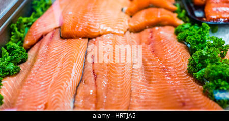 Stand de fruits de mer avec les compressions et les filets de saumon sur glace avec feuilles de chou Banque D'Images