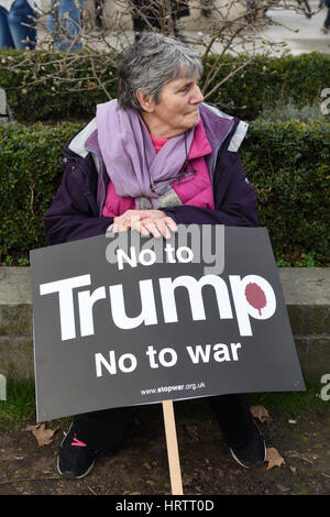 Une femme âgée est holding a placard lire : "Non à l'atout, non à la guerre" au cours de l'Escale Trump & Stop Brexit manifestation à Parliament Square, Londres. Banque D'Images