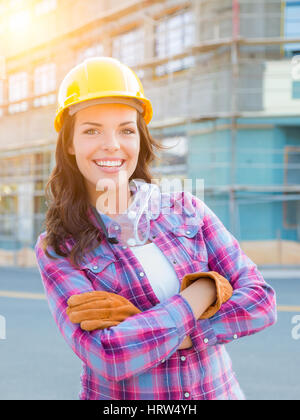 Portrait of young female Construction Worker Wearing gants, casque et lunettes de protection au chantier de construction. Banque D'Images