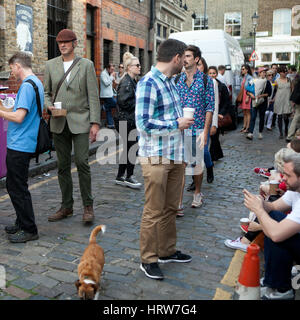 Londres, Angleterre - le 12 juillet 2016 fleur dimanche Columbia Road Flower Market. L'objectif local fleur, assis sur les trottoirs, boire du vin, manger et écrire un Banque D'Images