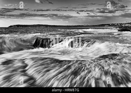 Surf solide et splash vague cassée sur la côte près de Maroubra beach à Sydney, Australie côte du Pacifique. Réchauffer la lumière du matin sur l'eau et de l'océan bleu blanc Banque D'Images