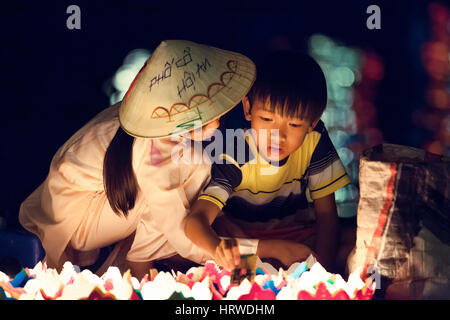 Hoi An, Vietnam - Mars 14, 2014 : filles et garçons vietnamiens vendent des bougies pour les touristes à Hoi An, ville ancienne de nuit. Banque D'Images
