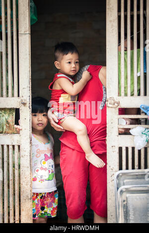 Hanoi, Vietnam - le 26 avril 2014 : Portrait de famille vietnamienne à l'entrée de leur maison sur la rue de Hanoï au Vietnam, le 26 avril 2014. Banque D'Images