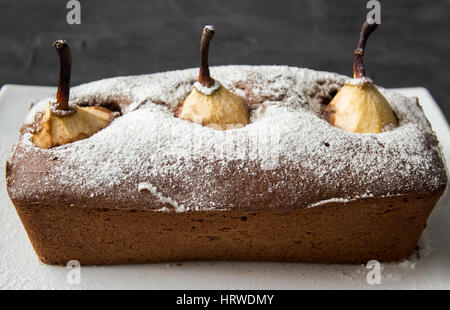 Gâteau au chocolat avec poire pochée sur fond sombre Banque D'Images