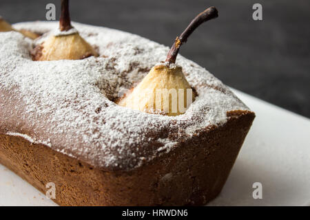 Gâteau au chocolat avec poire pochée sur fond sombre Banque D'Images