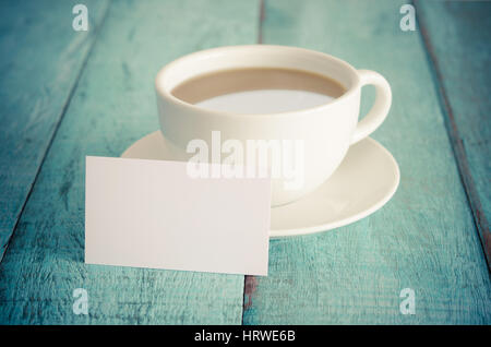 Blank business card et tasse de café sur la table en bois bleu. Filtre vintage. Banque D'Images