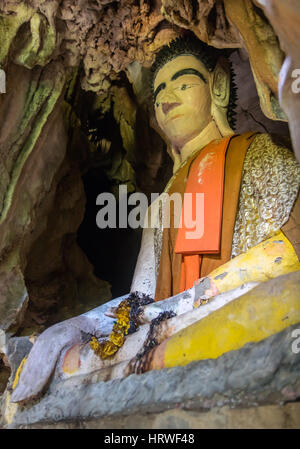 Statue de Bouddha assis dans une grotte. Habillé Statue de Bouddha assis en posture de méditation, le Laos. Banque D'Images