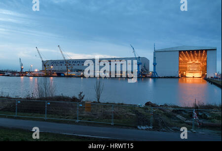 La nouvelle 334 mètres de long bateau de croisière norvégien 'Joy' est toujours considéré l'hiver aube couverts par la construction du quai du chantier Meyer de Papenburg, Allemagne, 04 mars 2017. Le navire géant sous peu s'est pas amarré et prises pour l'équipement pier. 'Joy' norvégienne est le plus grand navire jamais construit au chantier Meyer et le quatrième navire à passagers. À la fin de mars, la nouvelle construction pour l'US Shipping Company 'Norwegian Cruise Line" sera transférée à la mer du Nord sur l'étroite rivière Ems. Photo : Ingo Wagner/dpa Banque D'Images