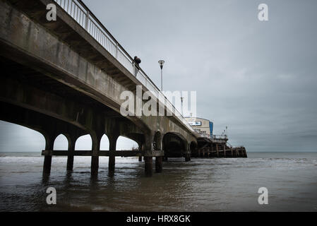 Un homme prend une photo pendant que se tenait sur la jetée sur une journée l'hiver dans le Dorset, UK. Banque D'Images