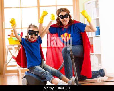 Super-héros Forte femme au foyer et kid fille prête pour le nettoyage de la chambre. Ménage ménage et concept. Banque D'Images