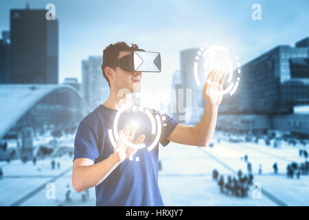 Double exposition d'une personne qui porte la réalité virtuelle (RV) ou casque visualisation (HMD) verres et de toucher les boutons et une ville en arrière-plan, Banque D'Images
