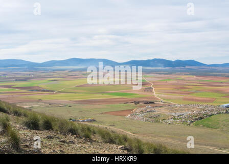 Vue d'une colline de champs, de fermes et de montagnes près de Consuegra ville au printemps jour nuageux. Banque D'Images