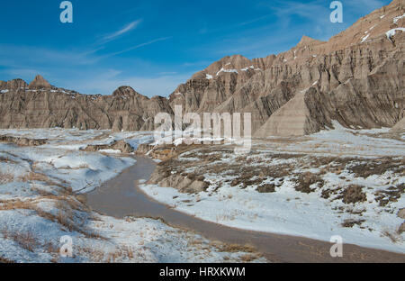 S'écoulant Arroyo : un flux lit qui est habituellement sec se remplit de neige fondante sur une journée d'hiver de Badlands National Park. Banque D'Images