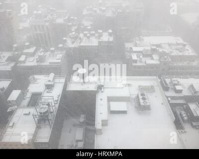 Regardant par la fenêtre d'un gratte-ciel sur le toits couverts de neige ci-dessous, des réservoirs d'eau, unités de climatisation, et les toits couverts de neige à Midtown Banque D'Images