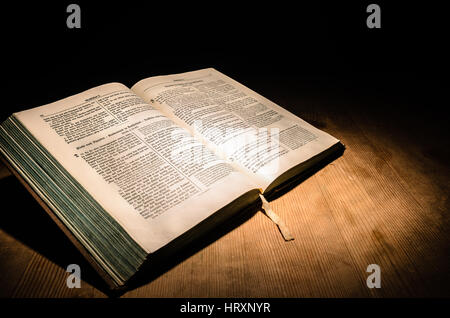 Vieille bible sur une table en bois avec fond sombre Banque D'Images