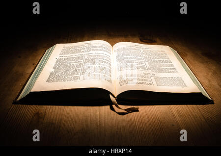 Vieille bible sur une table en bois avec fond sombre Banque D'Images