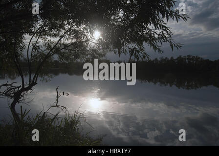 Coucher du soleil au-dessus de l'étang avec des arbres, soleil et ciel avec nuages près de Polanka nad Odrou dans Poodri CHKO près de la ville d'Ostrava en République Tchèque Banque D'Images