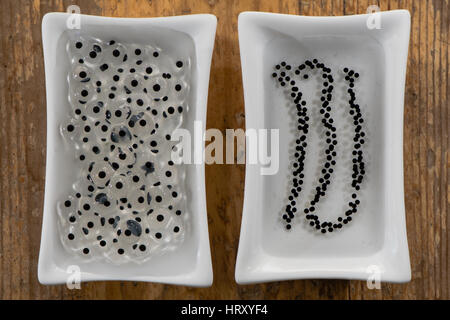 La rogue de grenouilles et de crapauds de comparaison. Oeufs de grenouille rousse (Rana temporaria) (à gauche) et crapaud commun (Bufo bufo) (droit) côte à côte Banque D'Images