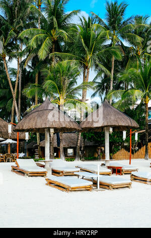 Nipa hut pare-soleil avec deux transats en bambou sur la plage de sable de corail blanc Banque D'Images