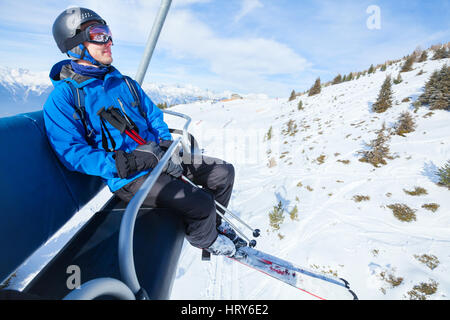 Skieur heureux sur l'élévateur de ski en hiver montagne Banque D'Images