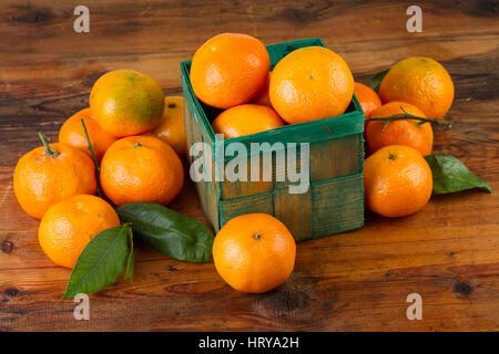 La mandarine mandarine fruits en boîte verte sur la vieille table en bois Banque D'Images