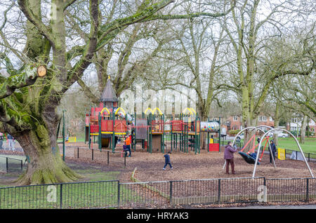 Recherche à travers le parc prospect dans la lecture sur l'aire de jeux avec portique et balançoire. Banque D'Images
