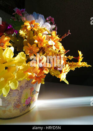 Bouquet de fleurs colorées se dresse sur une table éclairée par un rayon de soleil Banque D'Images