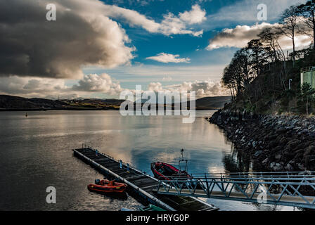 Montagnes Cuillin Hills, sur le Loch Portree, sur l'île de Skye, en Écosse, contre un ciel dramatique, en face de Portree Harbour landing stage. Banque D'Images