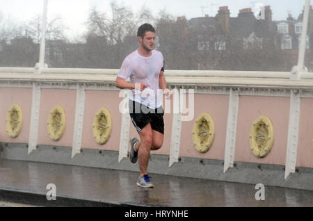 Londres, Royaume-Uni. 5 mars, 2017. Les Londoniens pris dans pluie torrentielle sur Albert Bridge le dimanche après-midi. Credit : JOHNNY ARMSTEAD/Alamy Live News Banque D'Images